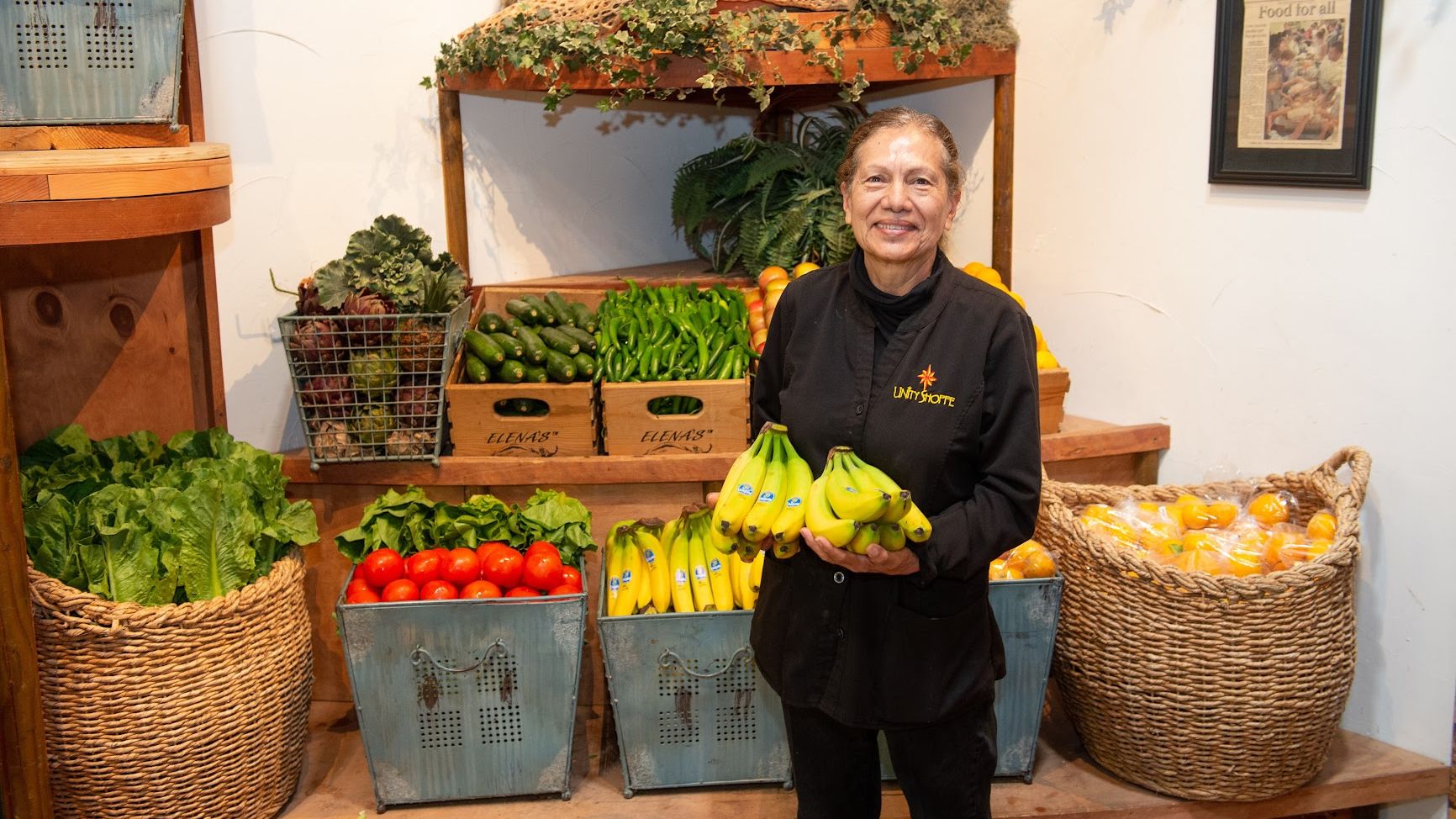 volunteer in the store holding bananas